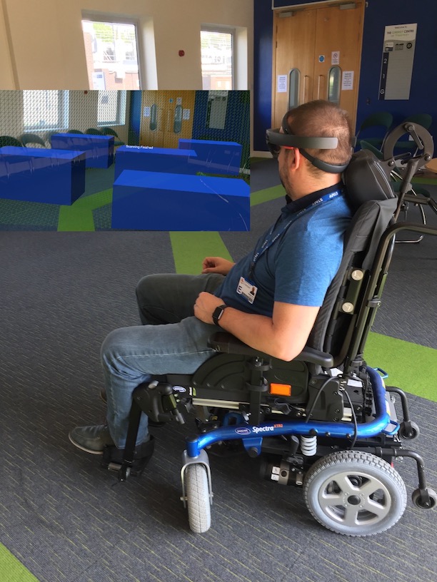Wearing the Hololens enables virtual obstacles to appear in the real world as the user manoeuvres the wheelchair around the room.
